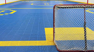 Un joueur de dek hockey junior protege la balle lors d un match a Trois-Rivieres